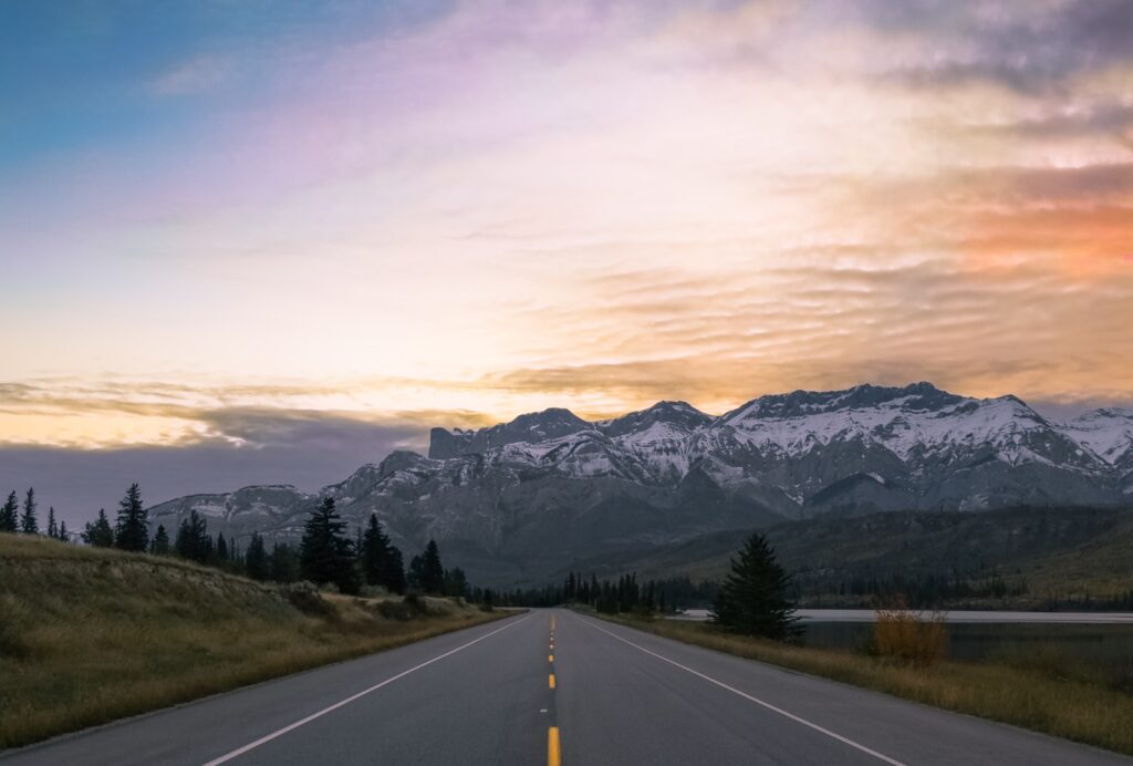 Photo of highway heading into Banff National park at sunset.