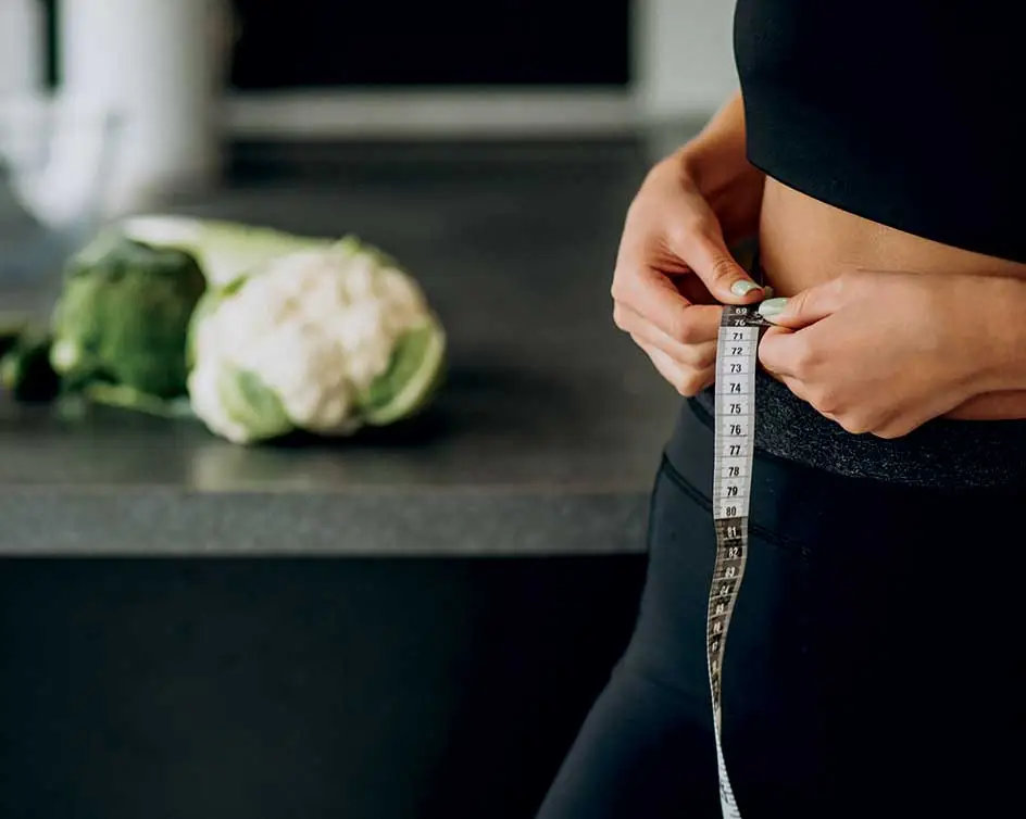 woman measuring her waist